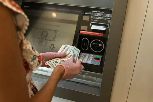 hands at cash machine