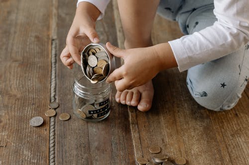 Child with coins in bottle