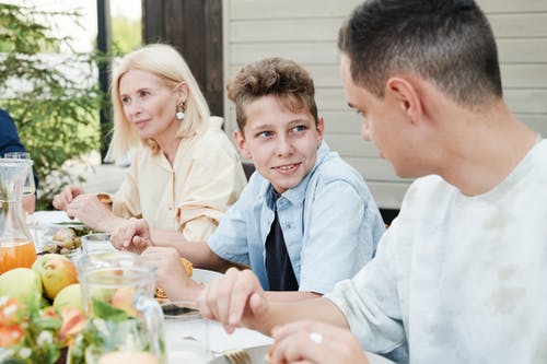 father talking to son at table