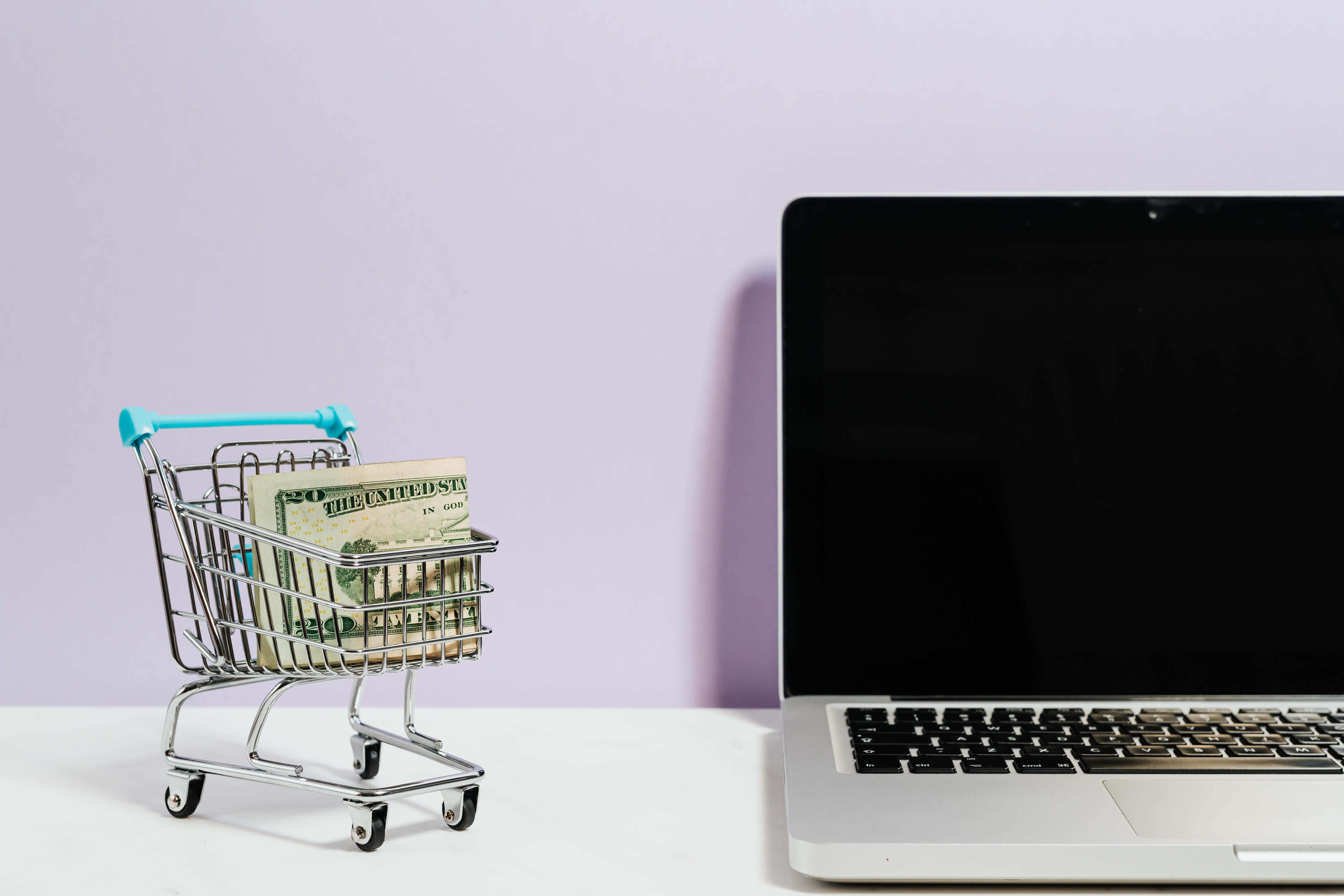 Mini grocery cart with cash beside computer